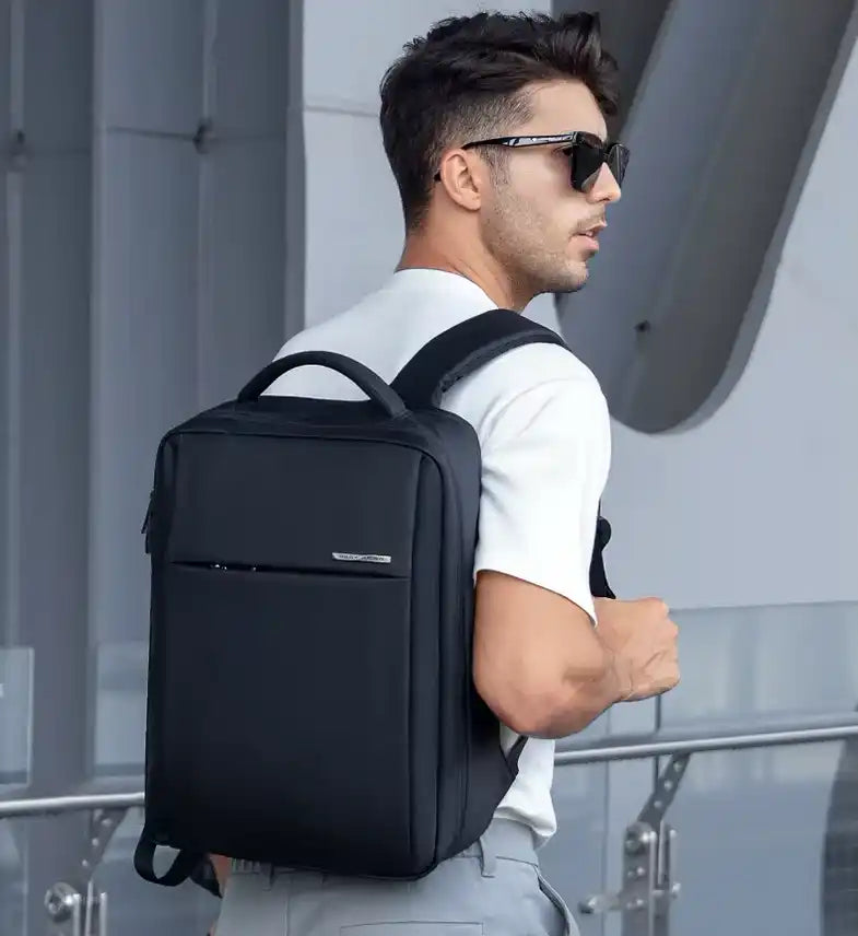 Sac à dos minimaliste noir avec une poignée supérieure et des bretelles.