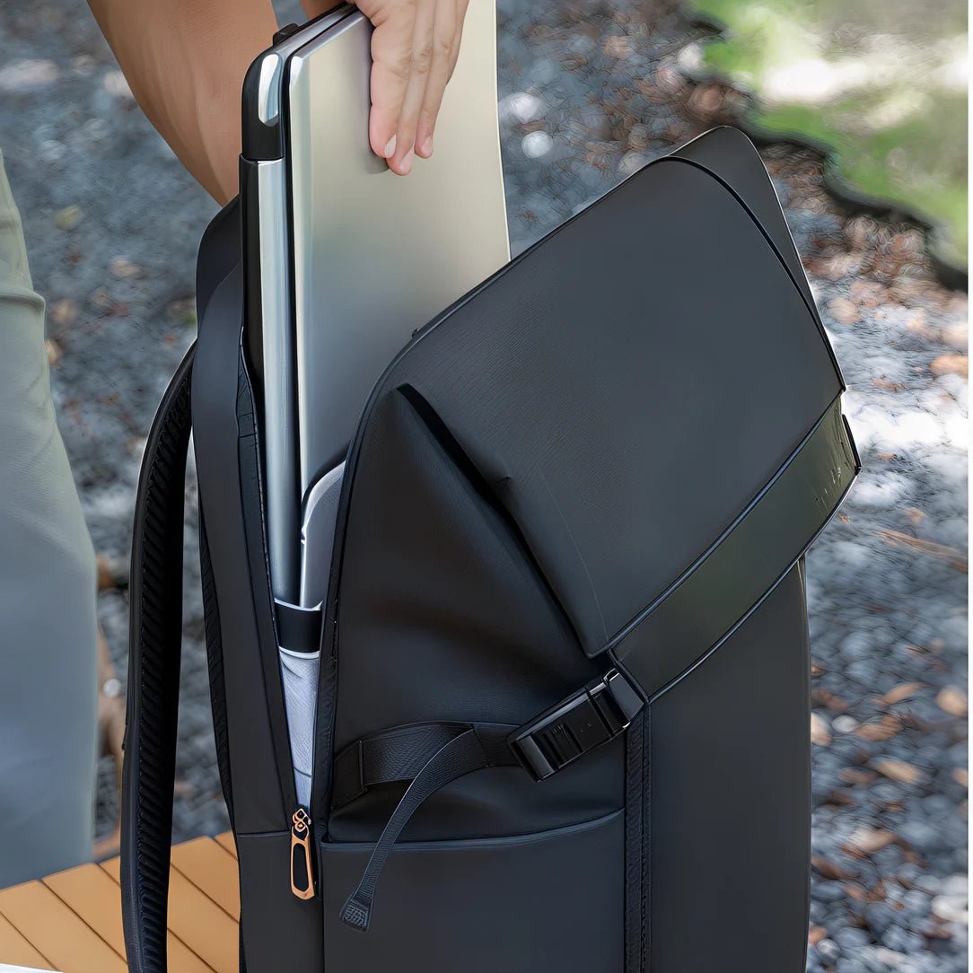 Person mettant un ordinateur portable argenté dans un sac à dos urbain imperméable Ryden I