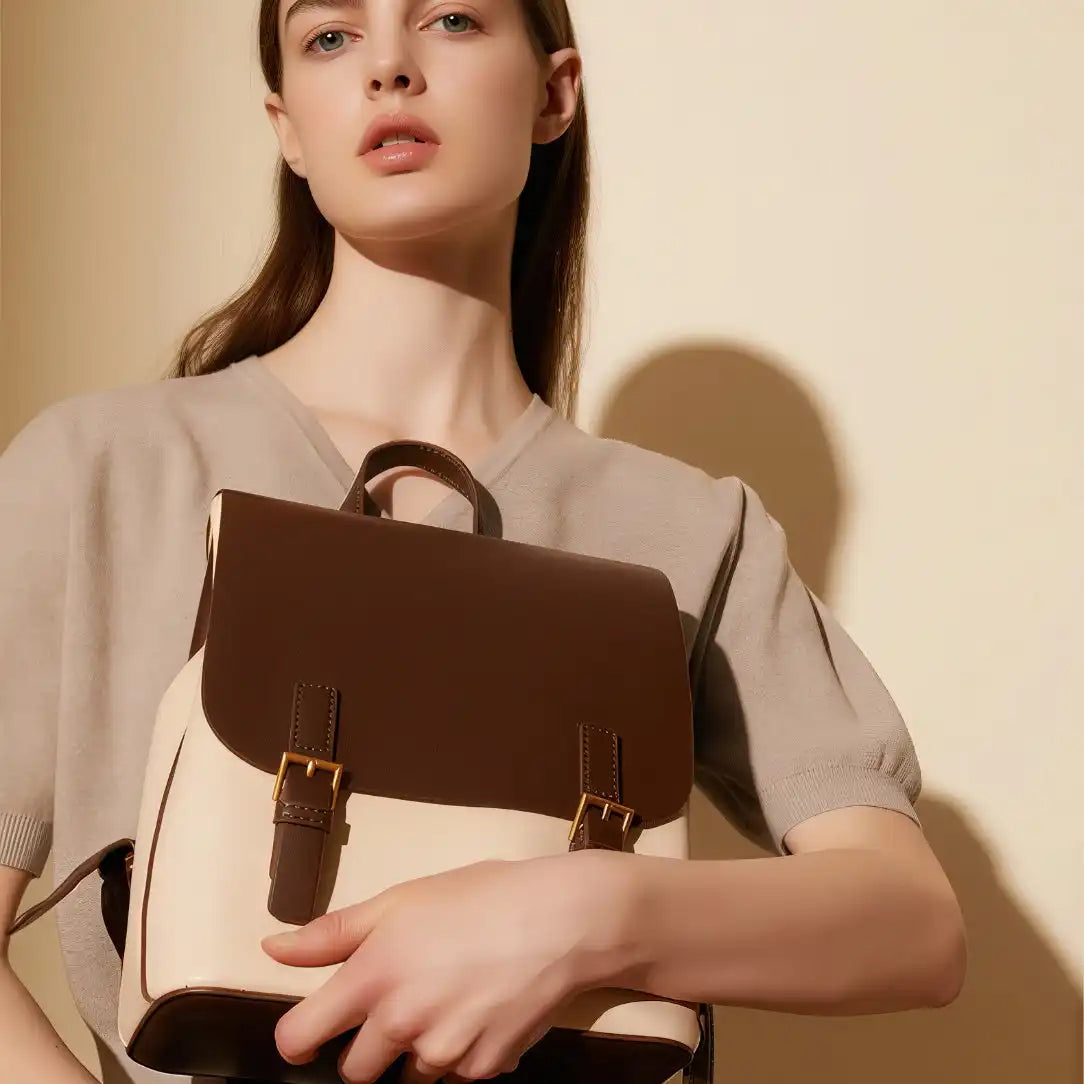Sac à boutonnière en cuir bicolore marron et crème avec ferrures dorées.