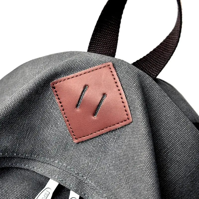 Sac à dos gris en tissu avec patch en faux cuir marron en forme de losange pour Cartable Garçon CE1