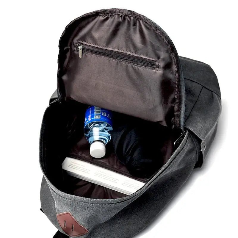 Sac à dos gris ouvert avec bouteille d’eau et livre pour garçon CE1