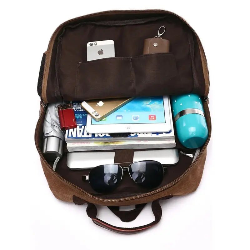 Sac à dos marron ouvert rempli d’objets personnels pour le travail homme
