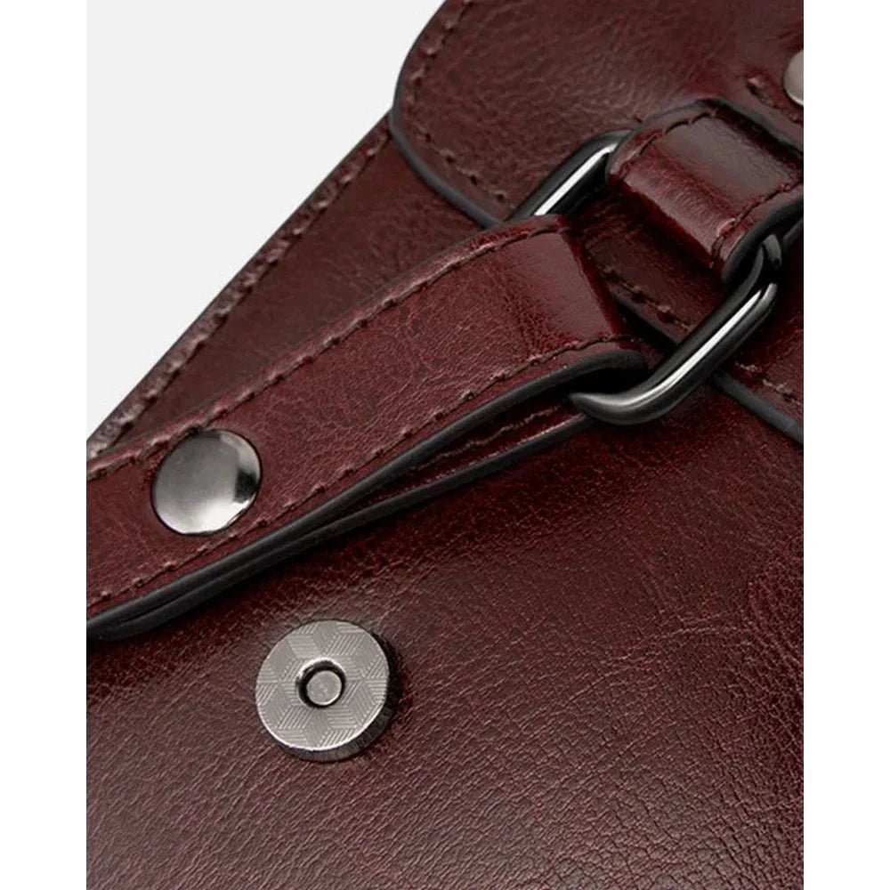 Vue rapprochée d’un cartable vintage en cuir bordeaux avec boucle et fermeture magnétique
