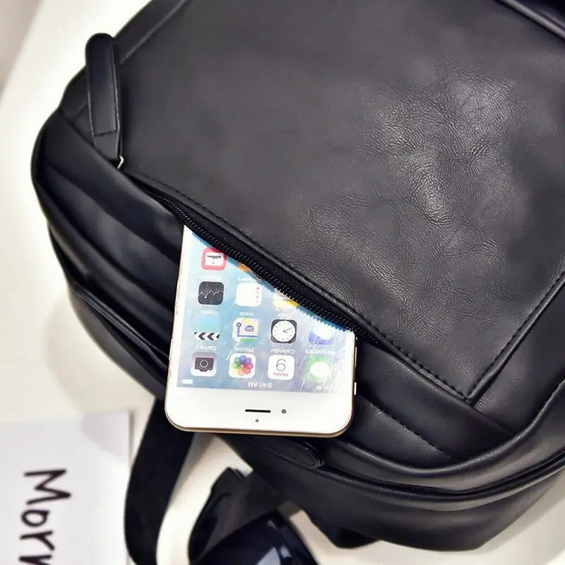 Sac à dos en cuir noir avec poche avant partiellement dézippée contenant un smartphone