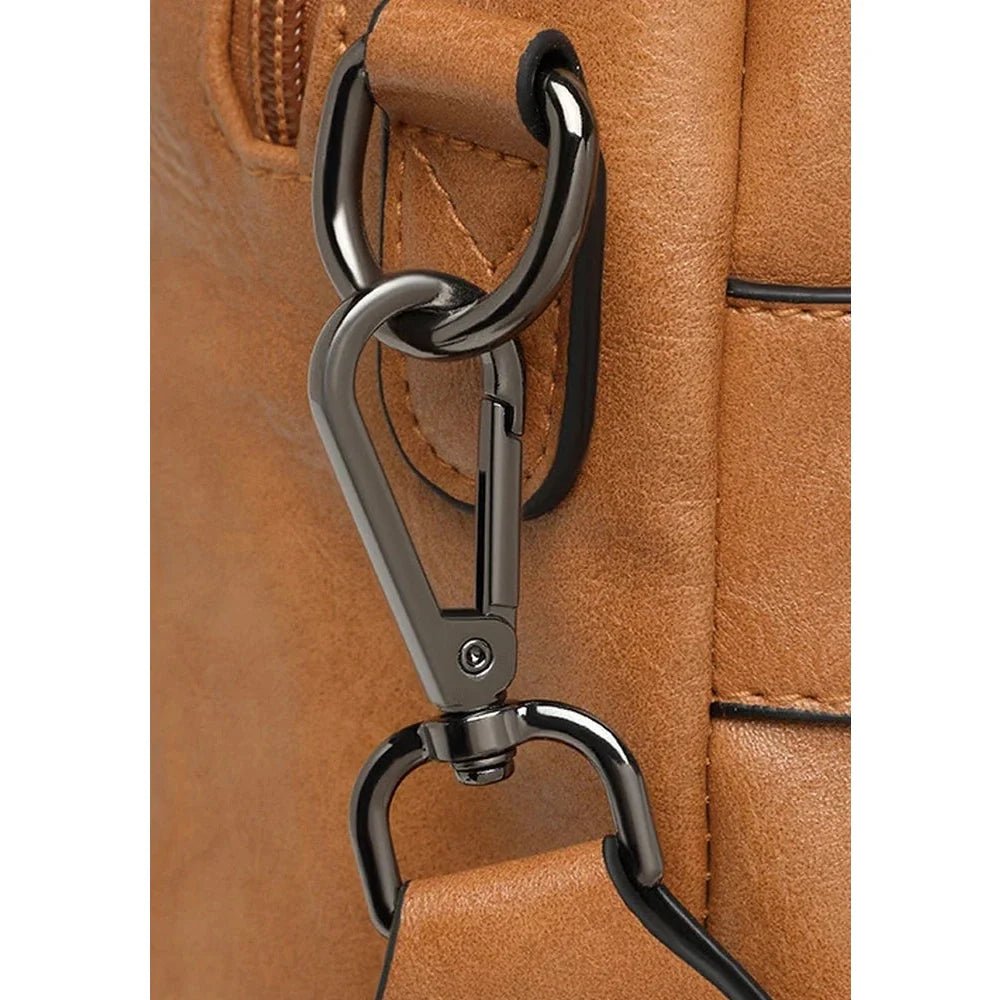 Gros plan d’un mousqueton en métal brun foncé sur un sac à dos en cuir tan Grand sac à dos en cuir oldschool