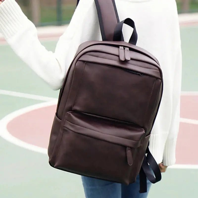 Sac à dos en cuir marron foncé avec deux compartiments principaux et une poche frontale