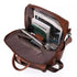 Sac à dos en similicuir marron ouvert avec livres, tablette et accessoires à l’intérieur