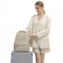 Sac à dos Amber beige avec accents dorés et design structuré élégant