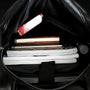 Sac à dos business homme cuir noir ouvert avec articles divers à l’intérieur