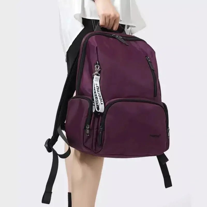 Sac à dos chic violet foncé avec compartiments zippés et porte-clés décoratif