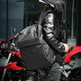 Sac à dos de moto noir porté par une personne en casque et veste en cuir