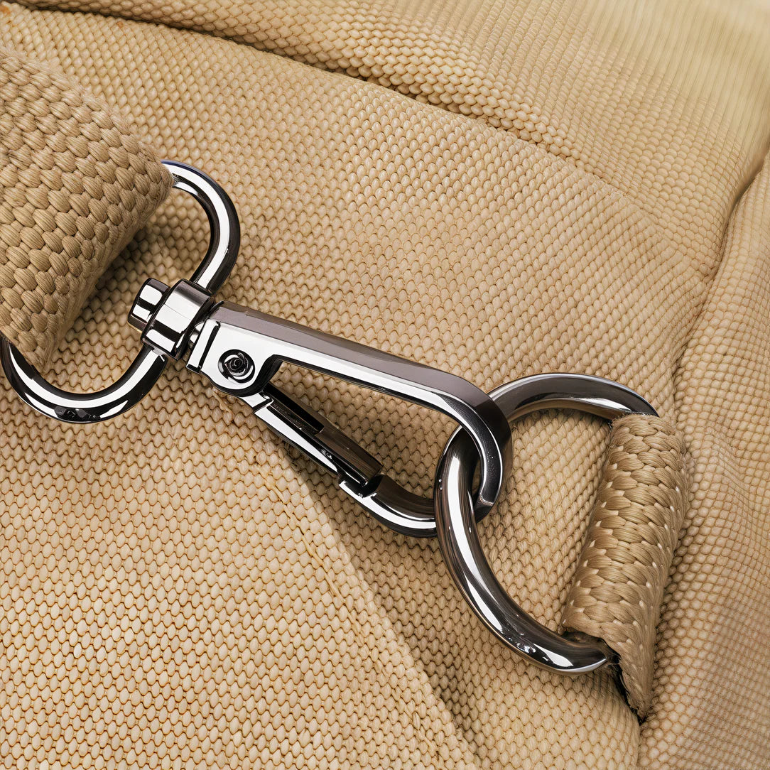 Mousqueton métallique argenté fixé à une sangle en tissu beige
