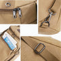 Sac à dos de voyage à bandoulière en toile beige avec fermetures éclair et clips métalliques argentés