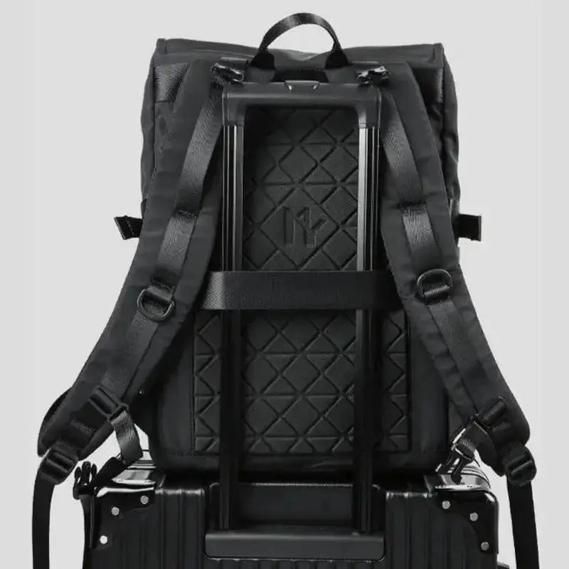 Sac à dos de voyage pour homme noir avec bretelles et sangle trolley sur une valise noire