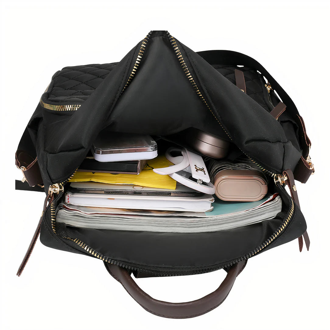 Sac à dos effet matelassé Céleste en cuir noir avec quincaillerie dorée et poignées marron