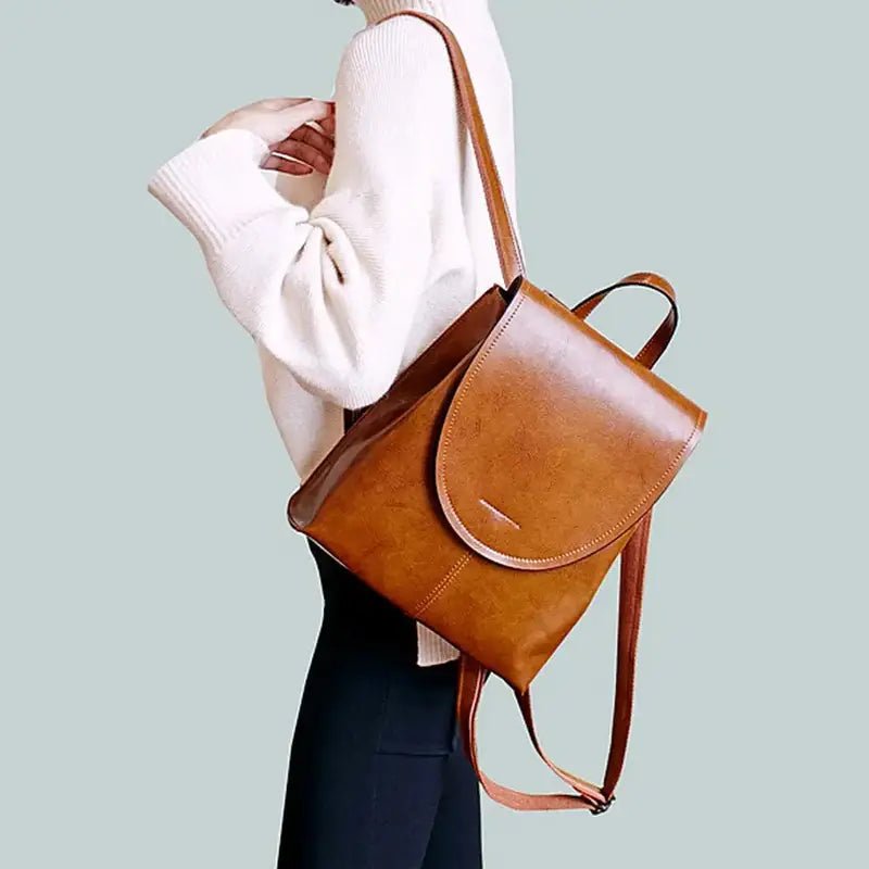 Sac à dos élégant en similicuir avec une fermeture à rabat incurvée et en cuir brillant