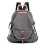 Sac à dos en tissu minimaliste gris foncé avec accents en cuir marron et poche frontale