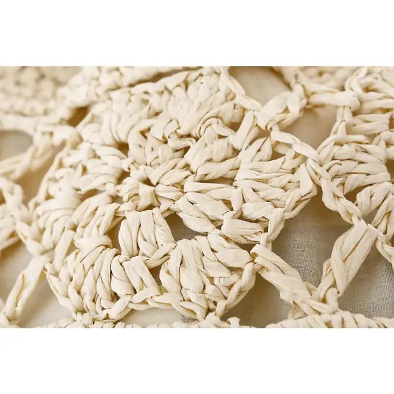 Détail en gros plan d’une couture en raphia crème pour Sac à dos femme paille
