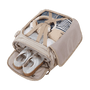 Sac à dos femme voyage cabine avec sac beige ouvert contenant vêtements, écouteurs et chaussures