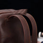 Sac à dos homme cuir vintage en cuir marron foncé avec couture visible sur les bretelles