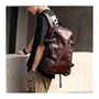 Sac à dos homme en cuir en faux cuir brun foncé avec plusieurs zippers et boucles