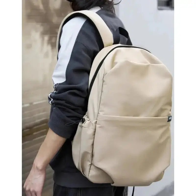 Sac à dos homme tendance beige en toile avec bordure noire pour style moderne