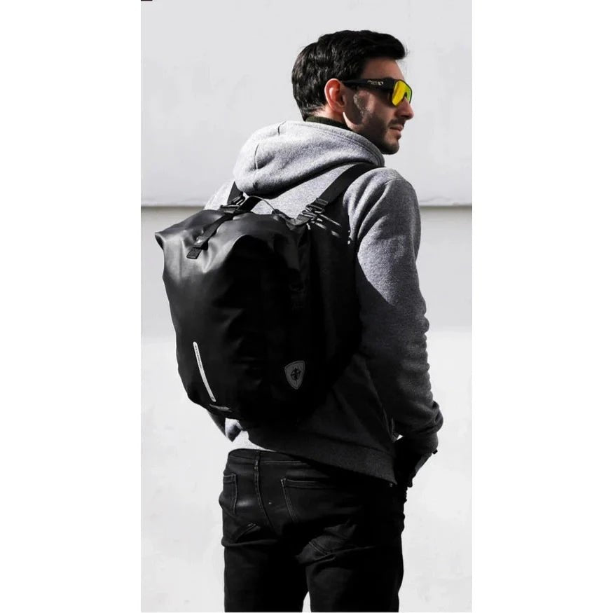 Homme portant un sac à dos imperméable vélo noir et des lunettes de soleil jaunes