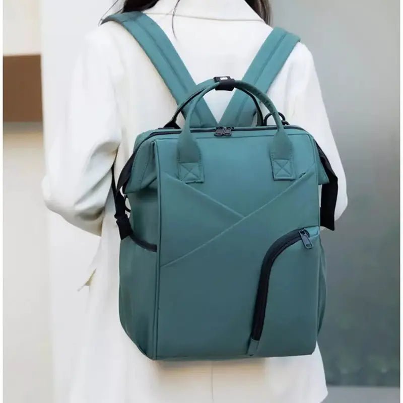 Sac à dos à langer chic teal avec plusieurs compartiments et poignées supérieures