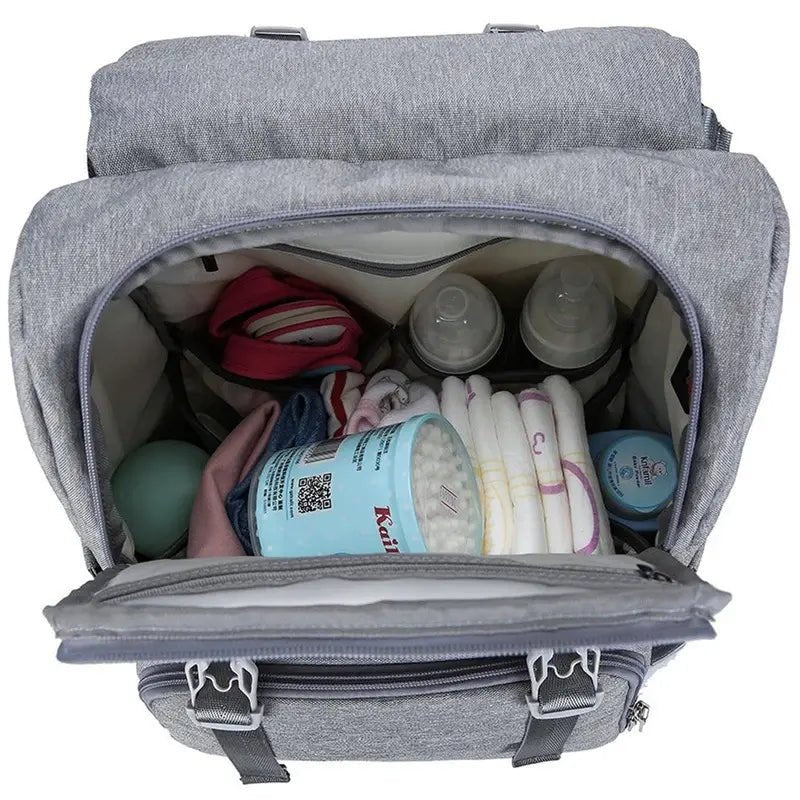 Sac à dos à langer ergonomique gris ouvert rempli d’essentiels pour bébé