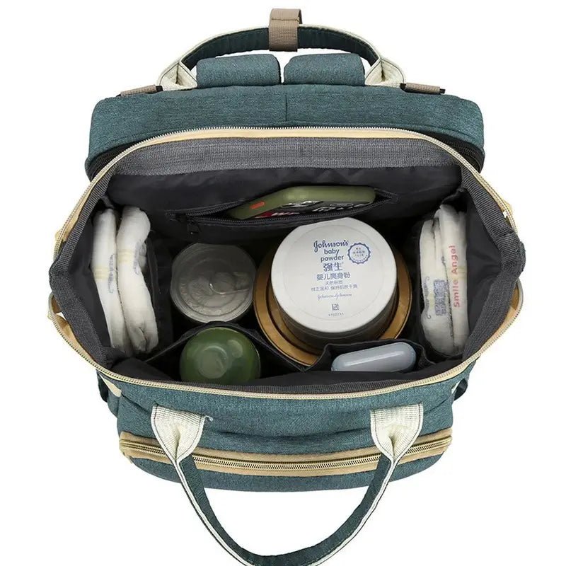 Sac à dos à langer lit ouvert avec essentiels pour bébé bien organisés