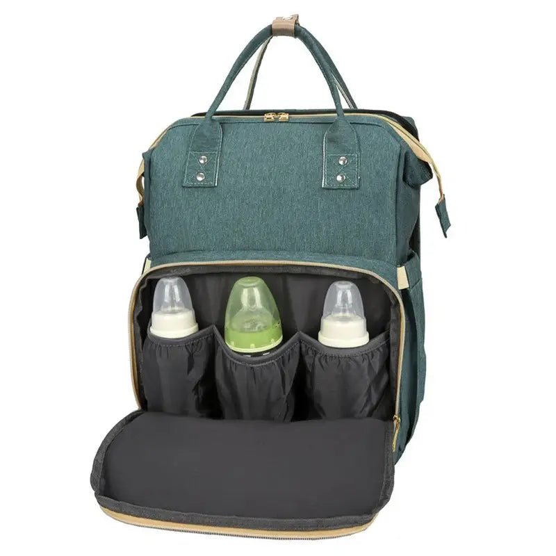 Sac à dos à langer lit en teal foncé avec poche avant ouverte et trois biberons pour bébé