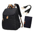 Sac à dos à langer noir en quilting avec accents tan, bandoulières détachables et tapis à langer assorti