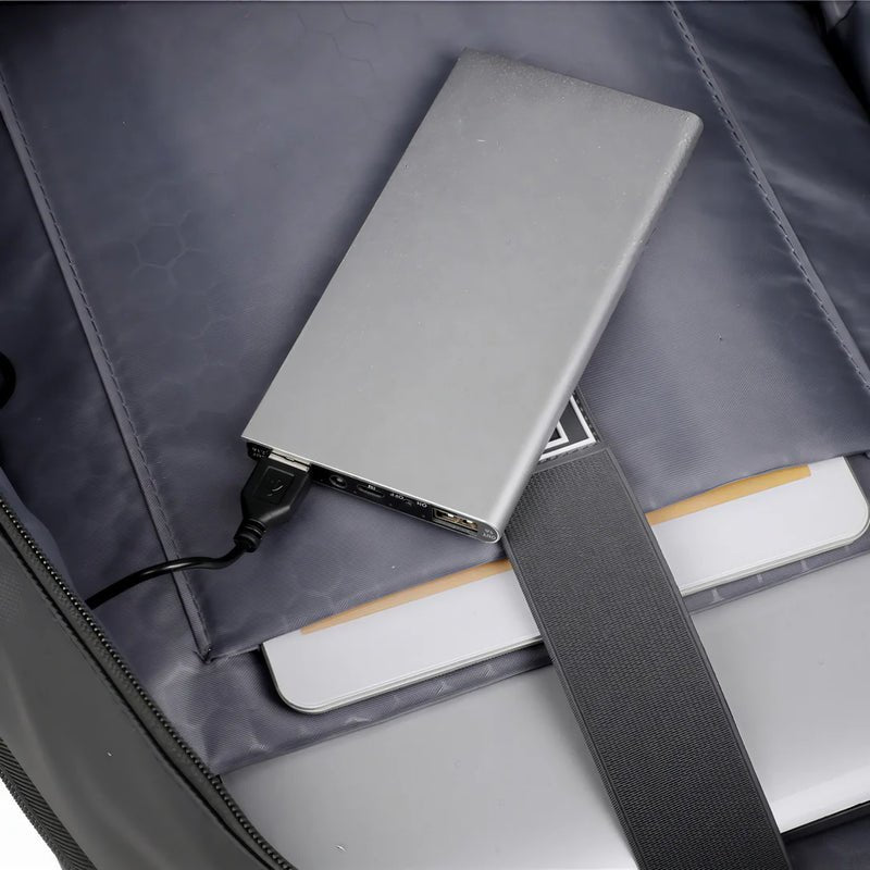 Power bank portable en argent avec câble USB connecté, idéal pour charger en déplacement