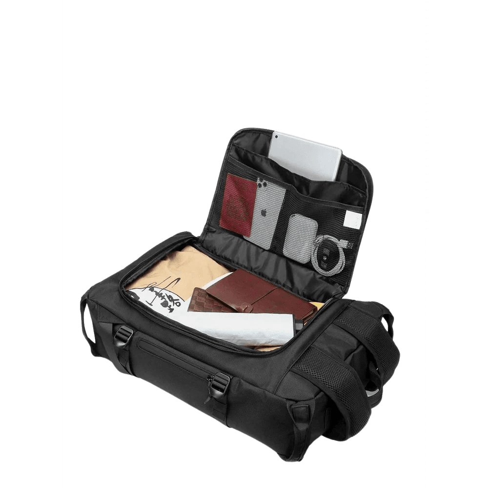 Sac à dos ouverture valise avec sac noir ouvert et divers articles dans ses compartiments