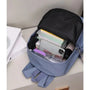 Sac à dos petite fille bleu ouvert avec livres, téléphone et lunettes de soleil