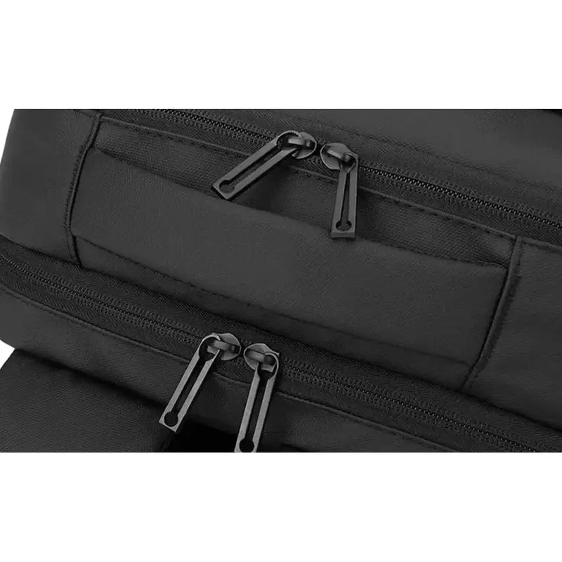 Vue rapprochée d’un sac à dos pour ordinateur portable homme en tissu noir avec plusieurs compartiments zippés
