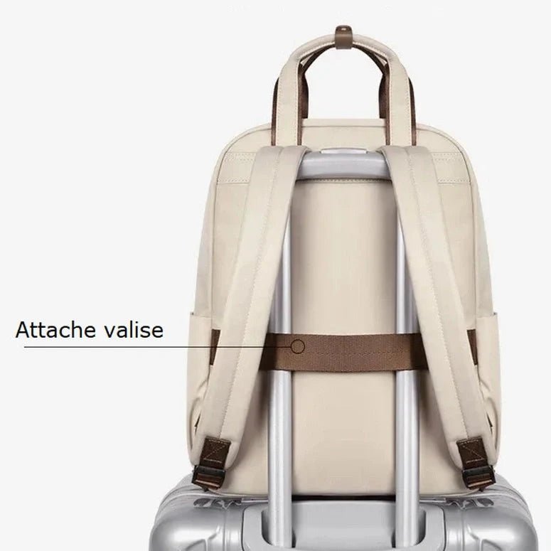 Sac à dos crème pour femme avec sangle de bagage sur une valise à roulettes