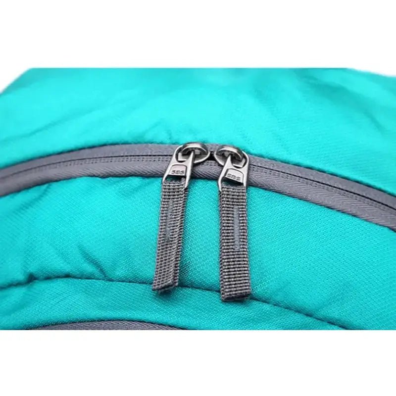 Zoom sur deux fermetures éclair parallèles sur un sac à dos randonnée étanche teal