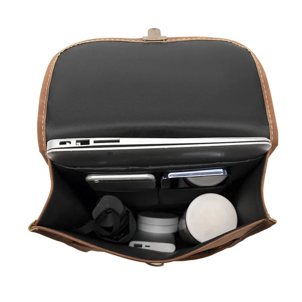 Sac à dos rectangulaire en cuir marron ouvert avec ordinateur portable et accessoires à l’intérieur