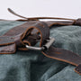 Détail de la boucle en métal sur la sangle en cuir marron foncé du Sac à dos Ruston