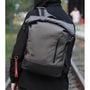Sac à dos roll top homme gris et noir avec poche verticale et accessoire clé rouge