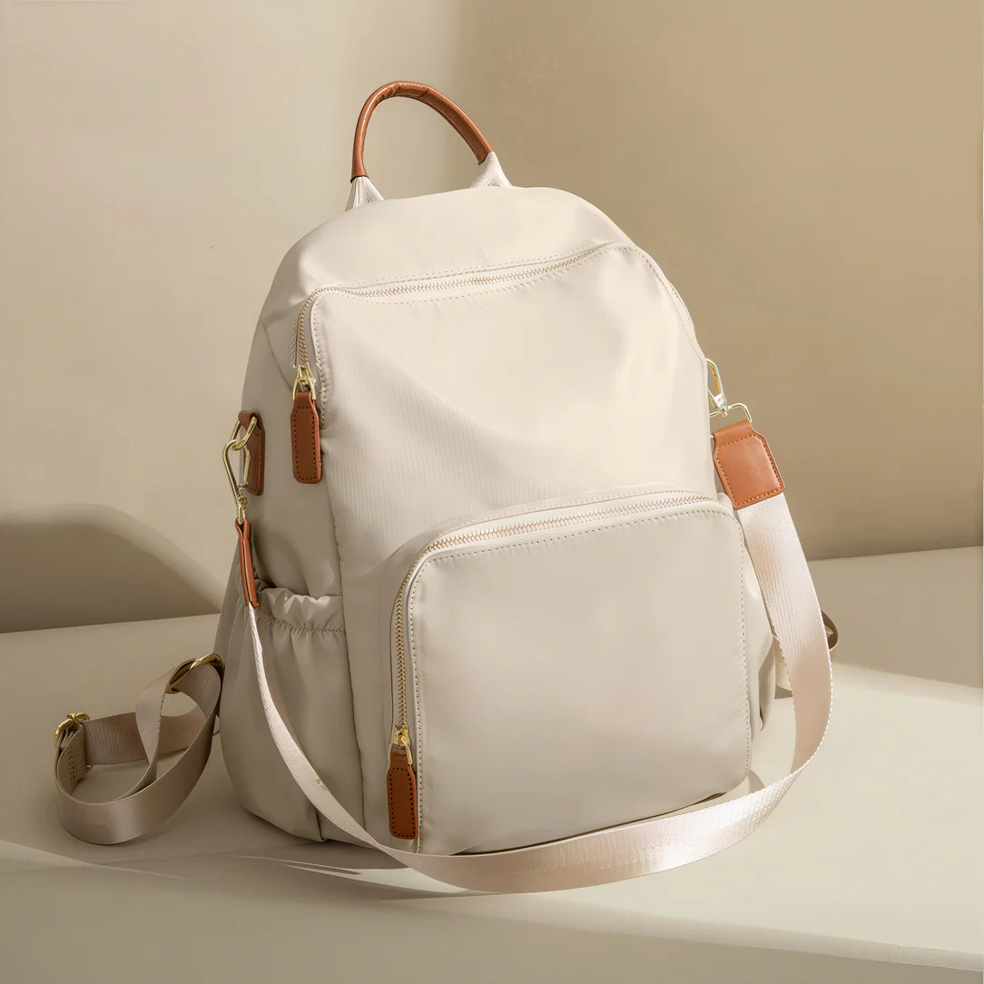 Sac à dos sable d’aube en nylon blanc avec accents en cuir marron et bretelles ajustables