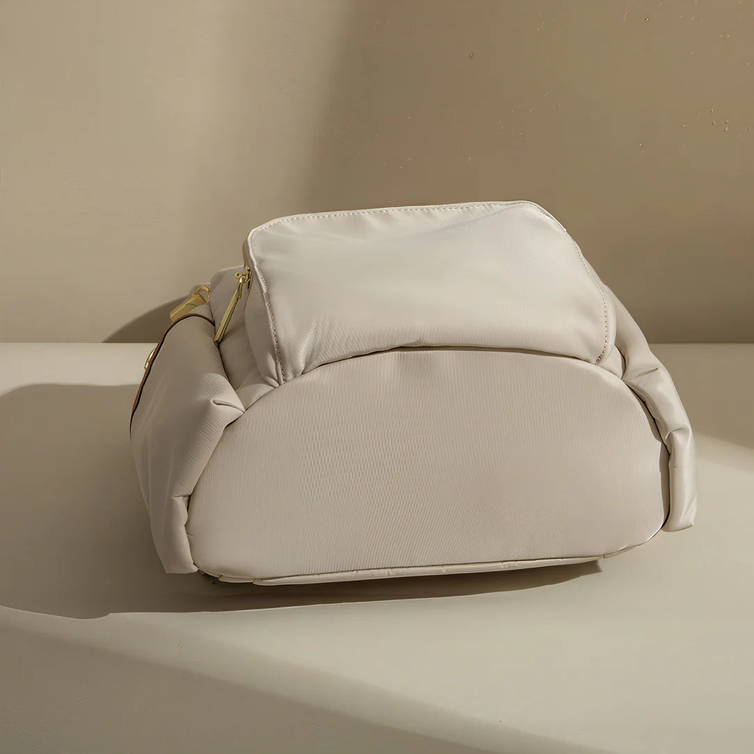 Sac à dos sable d’aube en tissu blanc texturé avec hardware doré et fermeture éclair