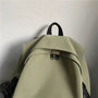 Sac à dos scolaire en nylon vert olive clair avec zippers noirs et poignée supérieure