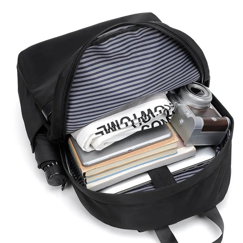 Sac à dos scolaire collège noir ouvert avec doublure rayée et contenu visible
