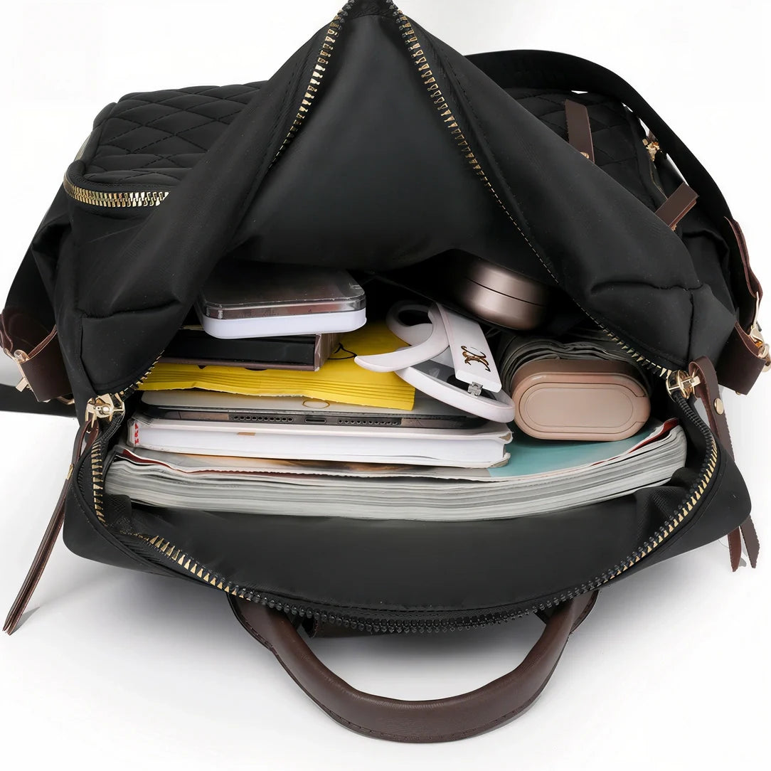 Sac à dos Sirocco en nylon noir avec fermetures dorées et accents cuir marron