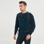 Sac à dos noir waterproof randonnée avec sangles ajustables et ceinture lombaire, porté par un homme en pull bleu marine