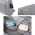 Sac à langer à dos en tissu gris clair avec plusieurs poches et compartiments