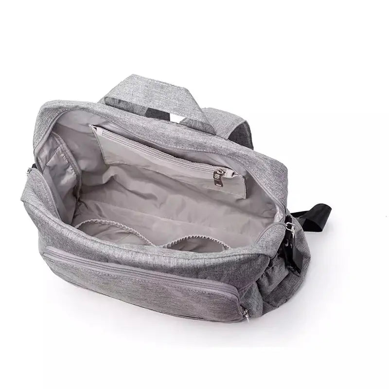 Sac à langer à dos gris ouvert avec multiples poches internes et externes