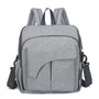 Sac à langer pour bébé en tissu gris clair à poches extérieures et bandoulière convertible